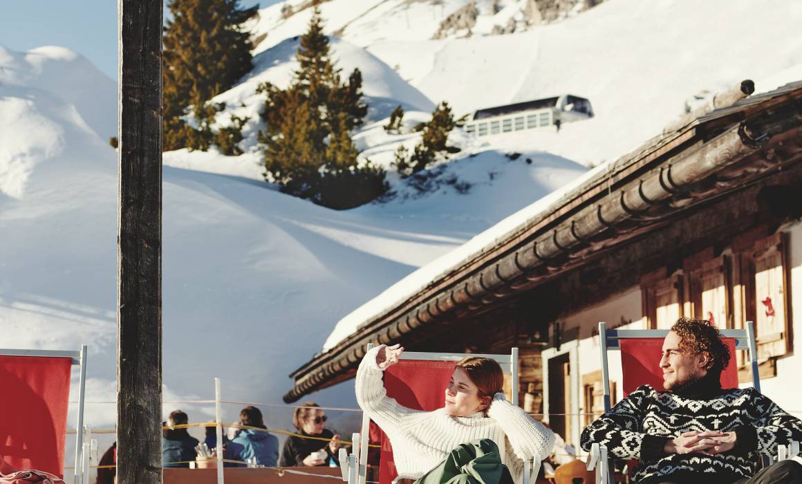 Skifahrer entspannen an Berghütte "Kriegeralpe" im Winter bei Schnee