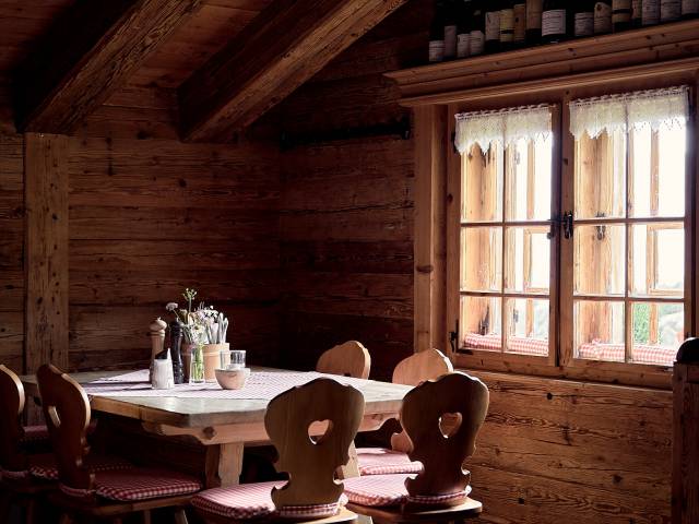 Tisch mit Holzstühlen in rustikaler Berghütte