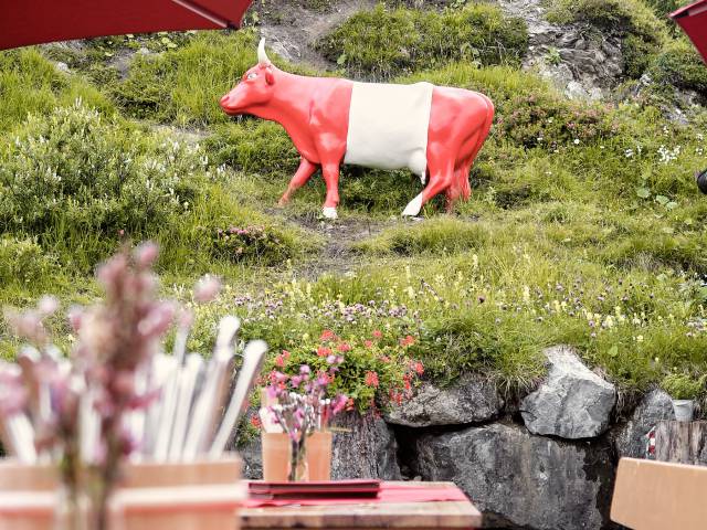 Sonnenterrasse mit Blick auf Deko-Kuh in Farben der Flagge von Österreich